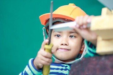 Asian boy dressed as a craftsman and holding tools	
