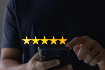 Customer service experience and business satisfaction survey concept. Man hand using mobile smartphone and give five star symbol to increase the rating of product and service on the online application