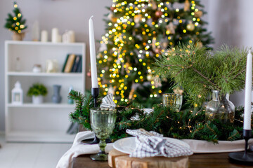 A festive Christmas table set with fir branches and lights