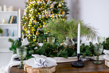 A festive Christmas table set with fir branches and lights