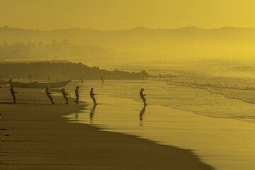 Fototapeta na wymiar silhouette of fisherman on the beach