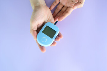 hand of people check diabetes and high blood glucose monitor with digital pressure gauge. Healthcare and Medical concept.
