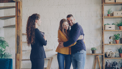 Real estate buyers are getting keys from housing agent after successful deal hugging with happiness...
