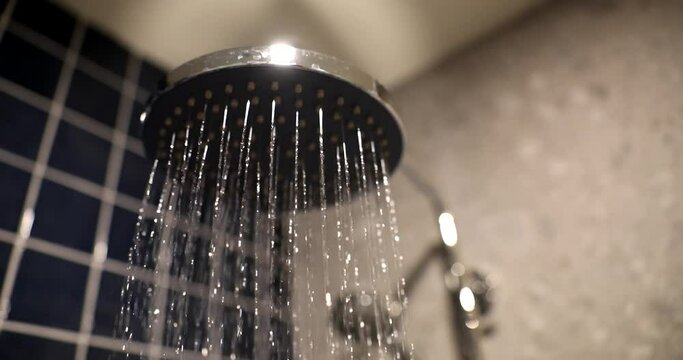 Closeup of stylish chrome shower spraying water