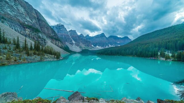 4K time-lapse UHD video of  beautiful view of an iconic famous place, Moraine Lake, a glacier lake located in Banff National Park,Alberta, Canada, in a colorful sunset cloudy summer autumn day. 