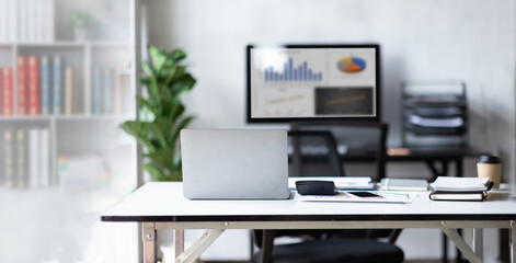 Laptop Computer, Minimal background image of inviting empty workplace with white desk and succulent plant in foreground, copy space after working hours
