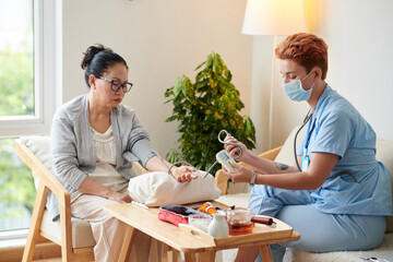 Nurse examining blood pressure of patient
