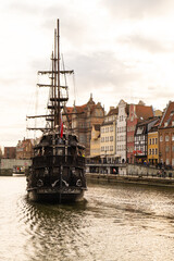 Beautiful old town of Gdansk over Motlawa river Vintage ship pirate caravels sailing on Motlawa...