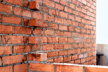 Obraz premium Construction of ceramic brick walls. Keramoblock. Hollow brick. Construction of a red brick house. Close-up. Material for the construction of walls and partitions.