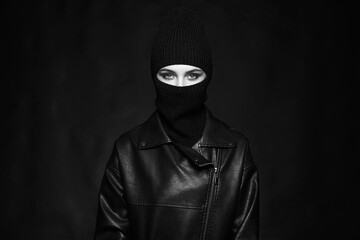 Fototapeta na wymiar Fashionable girl in balaclava and leather coat. Black and white portrait