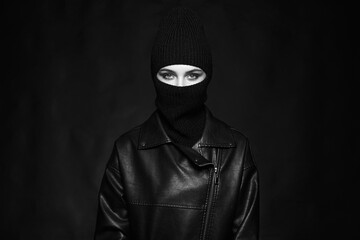 Fashionable girl in balaclava and leather coat. Black and white portrait