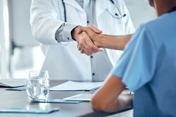 Doctor handshake, congratulations and nurse at office desk consulting on medical procedure,...