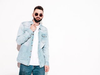 Portrait of handsome confident stylish hipster lambersexual model.Man dressed in jacket and jeans. Fashion male posing near wall in studio. Thoughtful. Isolated
