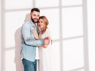 Smiling beautiful woman and her handsome boyfriend. Happy cheerful family having tender moments near wall in studio. Pure cheerful models hugging. Embracing each other. Cheerful and happy