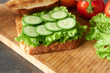 Toast with vegetables and herbs in close-up on a wooden background. The concept is healthy and wholesome food.
