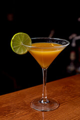 Primer plano de un delicioso c&oacute;ctel refrescante sobre una mesa de madera en un bar