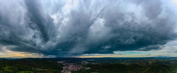 Aerial panorama view of distant light storm with rain showers, at sunset. Captured with a drone, in...