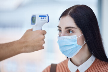 Thermometer, healthcare and covid with a doctor scan a patient temperature with infrared, checking for a fever. Sick woman with mask for corona, flu or cold in exam or consult in a medical clinic
