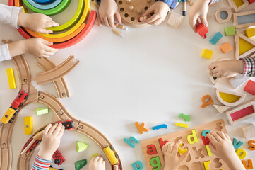 Children play wooden eco-friendly and colored toys. Dice, blocks, alphabet, railroad and board...