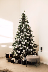Large Green Christmas Tree with gifts in the bright living room