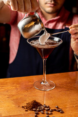 delicioso martini espresso en un vaso junto a granos de café sobre una mesa de madera
