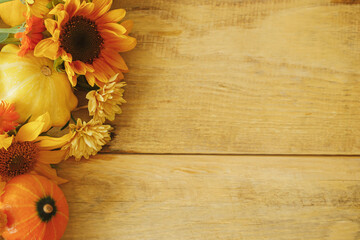 Colorful autumn flowers, pumpkins, pattypan squashes on wooden table flat lay. Seasons greeting card template, space for text. Autumn rustic banner. Harvest in countryside. Happy Thanksgiving!