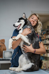 Fototapeta na wymiar Shot of cheerful dog and its female owner in modern veterinary hospital.