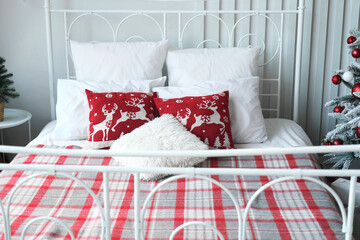 Christmas bedroom decor. Christmas pillows and checkered blanket on double bed