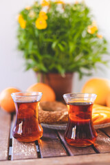 Turkish tea, sesame bagel and oranges on wooden table