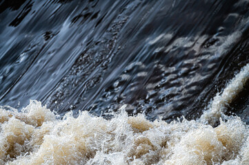 close up of flowing water, rapid water splashes of an white water river or stream, bubbly water