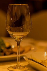 Kieliszek do wina stojący na zastawionym stole , podczas uroczystego przyjęcia .
