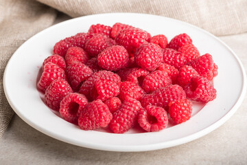 Plate with big yummy ripe organic raspberries Fresh summer berrys.