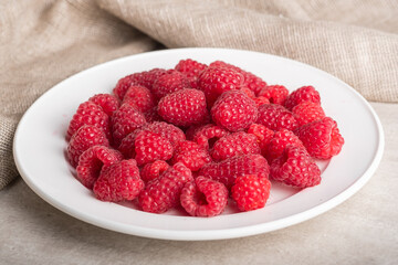Plate with big yummy ripe organic raspberries Fresh summer berrys.