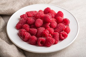 Plate with big yummy ripe organic raspberries Fresh summer berrys.