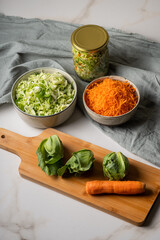 The preparation process fermentation preservation Sauerkraut. The best natural probiotic.Ingredients harvesting for gray cabbage soup: young green cabbage and carrots  on wooden board.