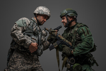 Fototapeta premium Studio shot of disagreements of russia and nato soldiers dressed in camouflage uniforms.