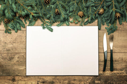 Menu Christmas dinner table. Menu mockup. blank white paper on rustic wooden background. Christmas menu concept with cutlery