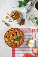 Homemade Dutch apple pie and ingredients on a light table and red napkin. top view
