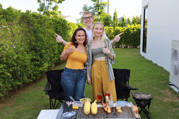 Group of happy family or friends with different ages making barbecue and celebrate outdoors with glass of red wine, grilling corn and enjoying BBQ party in backyard garden at home in summer day