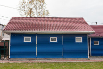 Blue wooden shed in the yard of the house