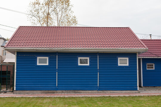 Blue wooden shed in the yard of the house