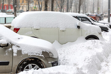 heavy snowfall cover parked cars on the street of town city