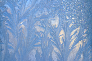 Frost pattern on a frozen window at winter. Natural background, texture