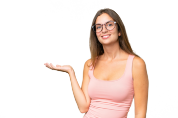 Young pretty woman over isolated background holding copyspace imaginary on the palm to insert an ad