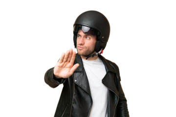 Young caucasian man with a motorcycle helmet isolated on green chroma background making stop gesture and disappointed