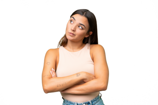 Young caucasian woman isolated on green chroma background making doubts gesture while lifting the shoulders