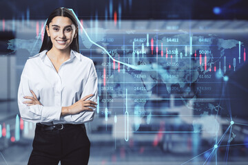 Attractive happy young european businesswoman with glowing candlestick forex chart and map hologram on blurry office interior background. Stock, investment, market and money concept. Double exposure.
