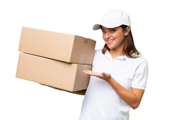Delivery caucasian woman holding boxes isolated on green chroma background extending hands to the side for inviting to come - obrazy, fototapety, plakaty
