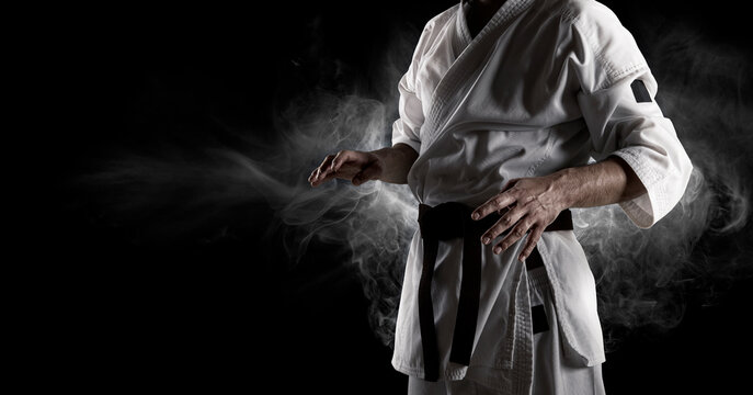 Karate master in white kimono with black belt