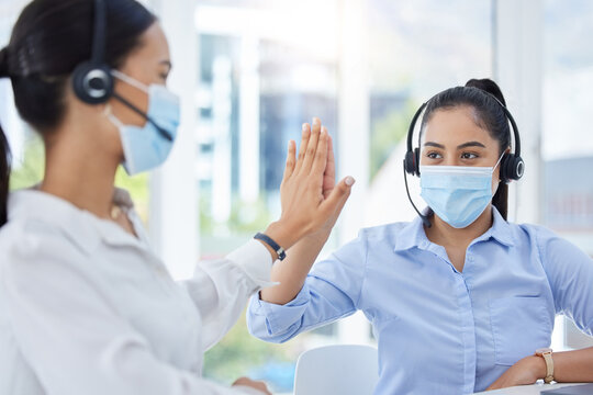 Covid, High Five And Women In Call Center With Face Mask For Office Compliance, Target Success Or Goal Achievement. Sales, Telemarketing Or E Commerce Business People Hands Teamwork, Support And Care